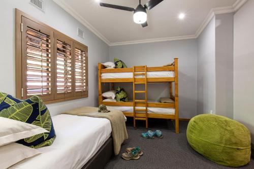 a bedroom with two bunk beds and a chair at Cavern Resort & Spa in Bergville