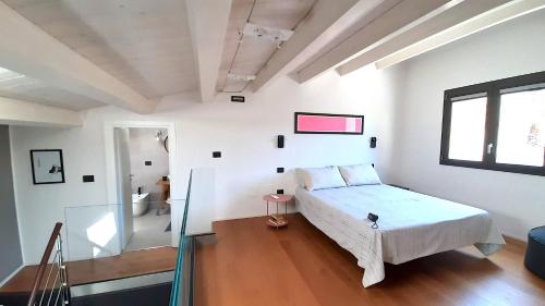 a white bedroom with a bed and a window at Le dimore di Palagonia in Bagheria