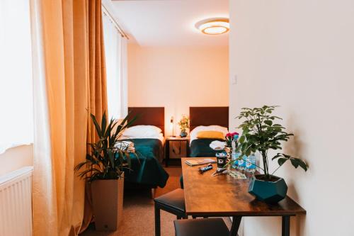 una habitación con 2 camas y una mesa con plantas en Kamieniczka Palladium en Gdansk
