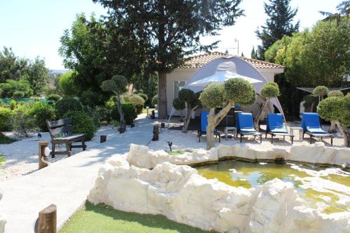 a garden with a pond with chairs and a gazebo at St.George's Country Retreat in Limassol