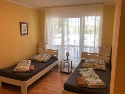 2 Betten in einem Zimmer mit Fenster in der Unterkunft Ferienhaus Gonsbach in Mainz