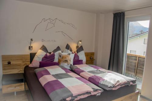 un gato sentado en una cama en un dormitorio en Ferienhaus Fux, en Bad Mitterndorf