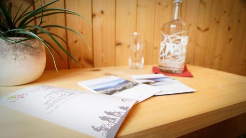 a wooden table with a plant and a bottle on it at Hotel Wynegg in Klosters