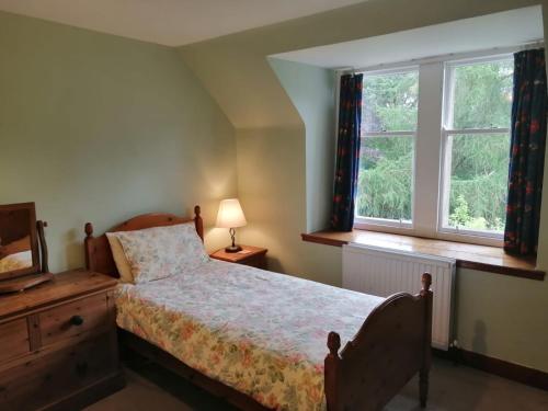 a bedroom with a bed and a window at The Maid's House in Lanark