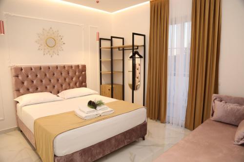 a bedroom with a large bed and a couch at Apartments Oda Hotel in Velipojë