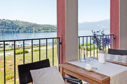 a table on a balcony with a view of the water at Hotel de Charme Laveno - Luxury all Inclusive in Laveno-Mombello