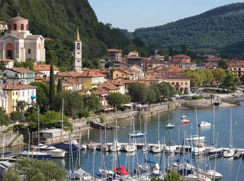 a group of boats docked in a harbor with a town at Hotel de Charme Laveno - Luxury all Inclusive in Laveno-Mombello