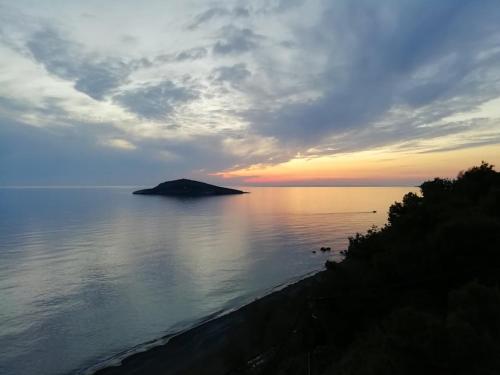 a sunset over the ocean with a small island at MOUSELIS APARTMENTS in Kalymnos