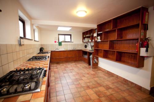 a large kitchen with wooden cabinets and a stove at Aille River Tourist Hostel Glamping Doolin in Doolin