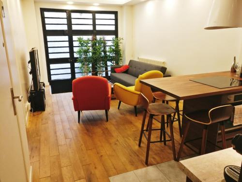 een woonkamer met een tafel, stoelen en een bank bij 3 double bedrooms apartment in Montmartre near subway AC in Parijs