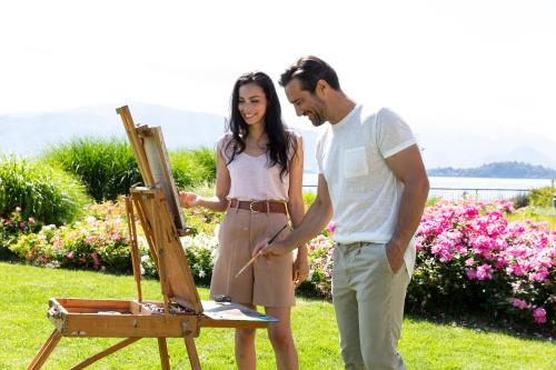 a man and a woman standing next to an easel at Hotel de Charme Laveno - Luxury all Inclusive in Laveno-Mombello