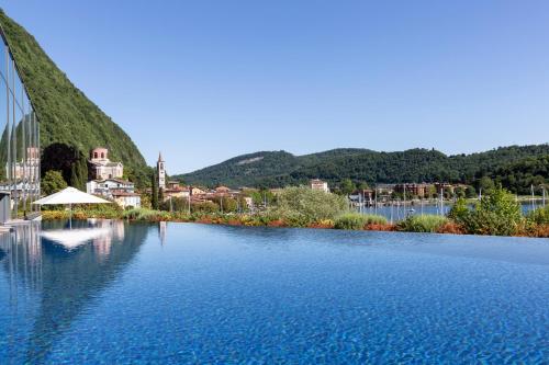 ein großer Wasserkörper mit einer Stadt im Hintergrund in der Unterkunft Hotel de Charme Laveno in Laveno-Mombello