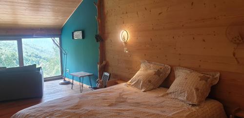 een slaapkamer met een bed met een houten muur bij Chambre d'hôtes à la ferme in Beaune