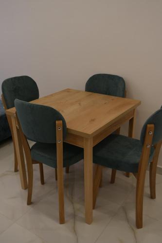 a wooden table with two chairs and a wooden table and chairsuggest at Apartments Oda Hotel in Velipojë