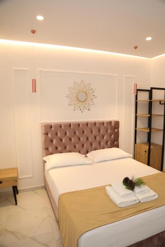 a bedroom with a large bed with a brown headboard at Apartments Oda Hotel in Velipojë