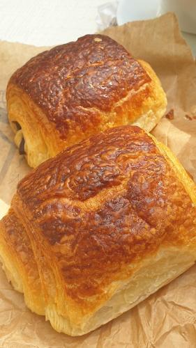 two pieces of bread sitting on a piece of paper at Chambre d'hôtes le petit Ranch in Los Masos