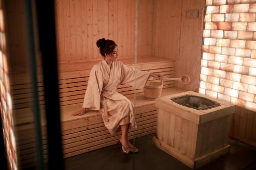 a woman sitting in a bath tub in a sauna at Stay Wellbeing & Lifestyle Resort in Rawai Beach