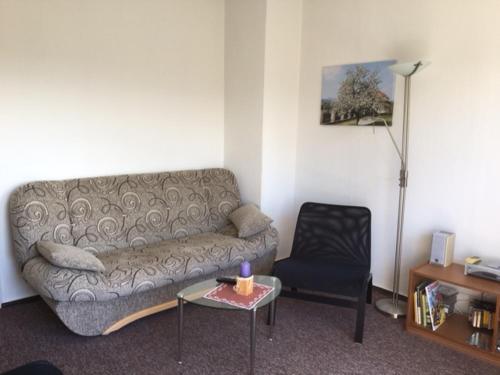 a living room with a couch and a chair at Ferienwohnung Graupner in Schwarzenberg