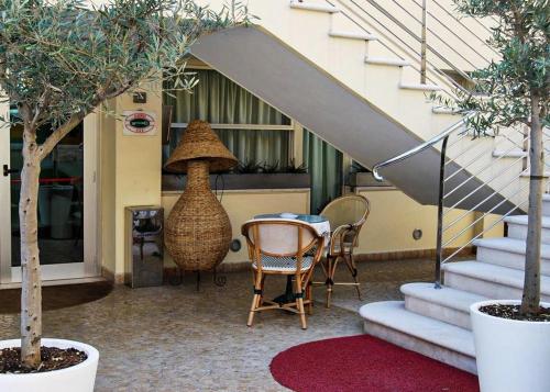 a table and chairs in front of a building at Hotel Acerboli in Rimini