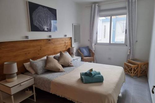 a bedroom with a large bed with a blue object on it at Casa Gales: Relax next to the Sea Apartment for Families in Corralejo