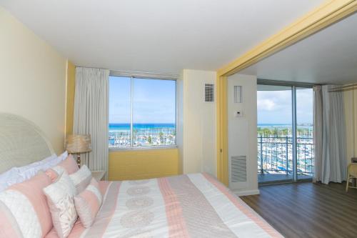 a bedroom with a bed and a view of the ocean at Spacious One Bedroom Harbor View Condos at Ilikai Marina With Private Balcony in Honolulu