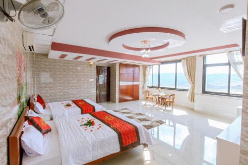 a bedroom with two beds and a dining room at Sai Gon Dak Nong Hotel in Gia Nghĩa