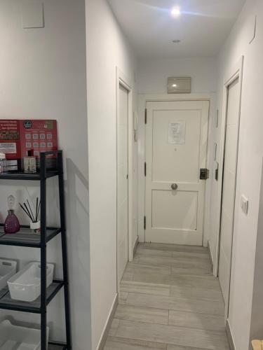 a hallway with white walls and a white door at ALOJAMIENTO CERRO DEL CABEZO in Andújar