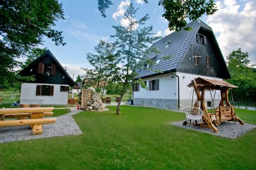 a yard with a house and a playground at B&B Plitvice Holiday Lodge in Plitvička Jezera