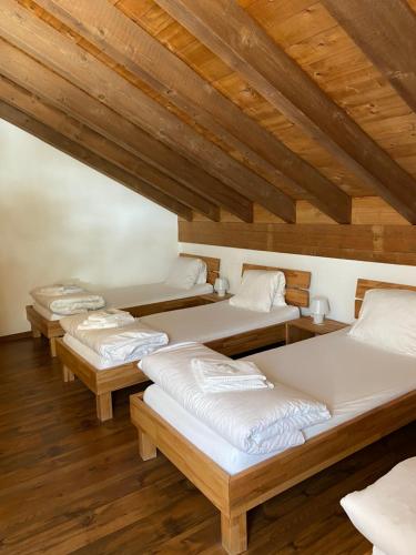 a row of beds in a room with wooden ceilings at Berggasthaus Piz Calmot in Andermatt