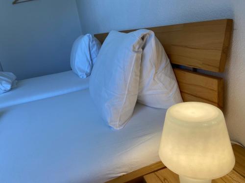 a bedroom with a bed with a white pillow at Berggasthaus Piz Calmot in Andermatt