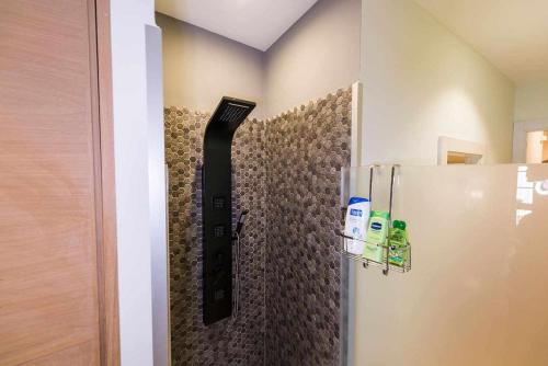 a shower with a black hose attached to a wall at Luxe Carlos Cañal in Seville