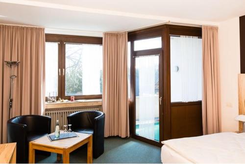 ニデッケンにあるHotel Roebのベッド、テーブル、椅子が備わるホテルルームです。
