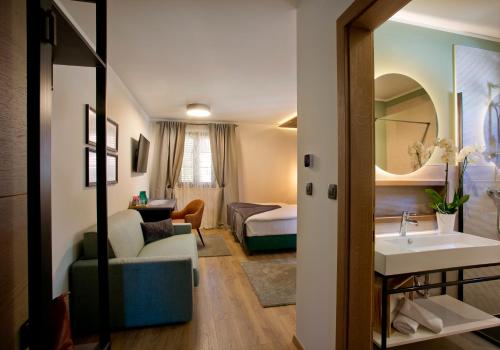 a hotel room with a sink and a bedroom at B&B Plitvice Holiday Lodge in Plitvička Jezera