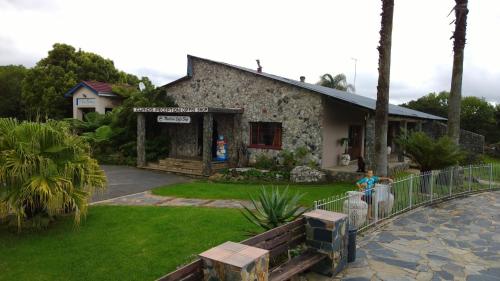 a person standing in front of a building at Panorama Chalets & Rest Camp in Graskop