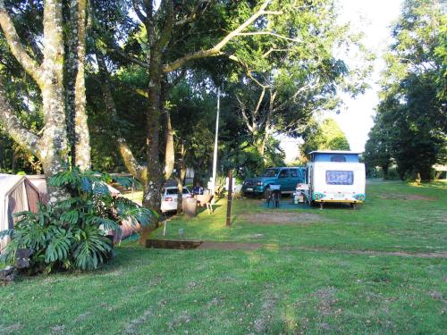 a group of vehicles parked in a field with trees at Panorama Chalets & Rest Camp in Graskop
