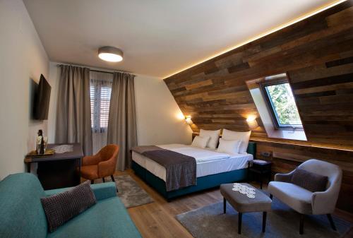 um quarto de hotel com uma cama e duas cadeiras em B&B Plitvice Holiday Lodge em Plitvicka Jezera