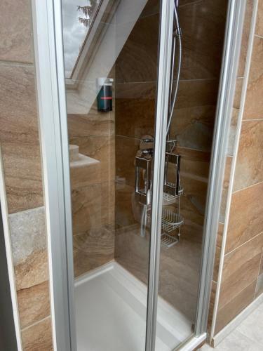 a glass shower door with a chair in a room at Casa Andrea 4 Zimmer Wohnung in Wallersdorf