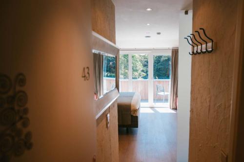 a hallway with a bedroom with a bed and a window at Hotel Le Val D'arimont in Malmedy