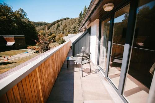 a balcony of a house with a chair on it at Hotel Le Val D'arimont in Malmedy