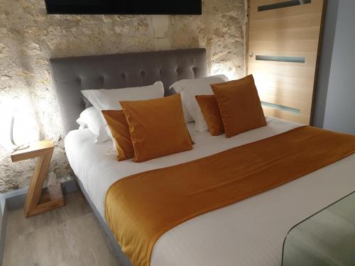 PontlevoyにあるLyzenのベッドルーム1室(大型ベッド1台、オレンジと白の枕付)