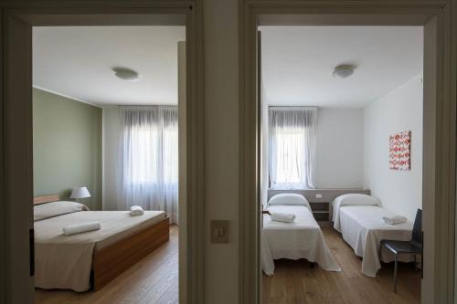 a hotel room with two beds and a mirror at Appartamento Calmo 1DX in Venice-Lido