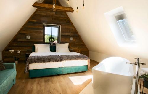 a attic bedroom with a bed and a bath tub at B&B Plitvice Holiday Lodge in Plitvička Jezera