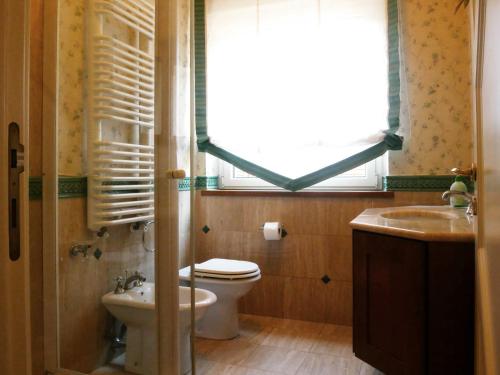 bagno con servizi igienici, lavandino e finestra di B&B Villa Floriana a Tortoreto
