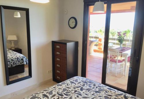 a bedroom with a bed and a dresser and a mirror at El Patio de Doña Julia in Bahia de Casares
