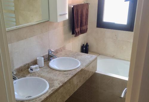 a bathroom with two sinks and a bath tub at El Patio de Doña Julia in Bahia de Casares