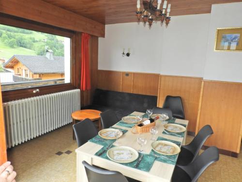 une salle à manger avec une table et des chaises et une fenêtre dans l'établissement Manoir 1 appt Les Gets, aux Gets