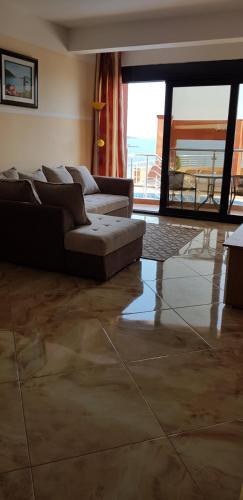 a living room with a couch and a large window at Apartment Sea Space 2 in Dobra Voda