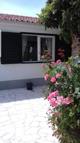 a house with pink flowers in front of a window at Smokvica in Split
