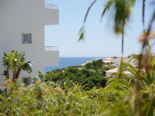 a view of a building and the ocean at Large Penthouse Near Porto de Mos Beach With Magnificent Views In Lagos in Lagos