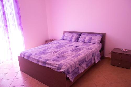 a bedroom with a bed with purple walls at Villa Lo Verde in Partinico